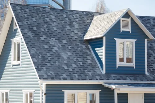 House with new shingle roof and blue siding